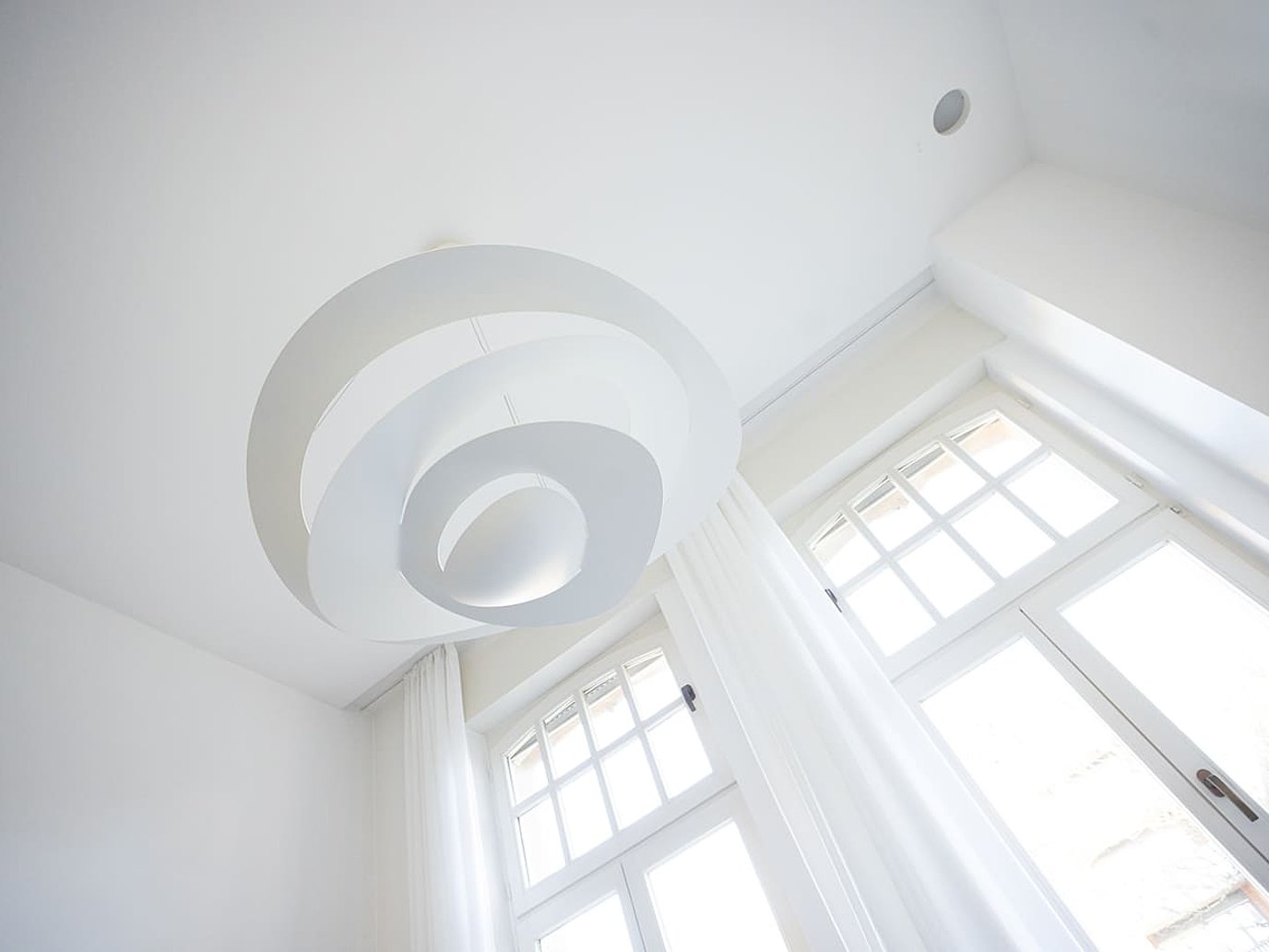 Blick von unten an die weiße Decke eines Büroraums mit Lampevon Beermann Partner